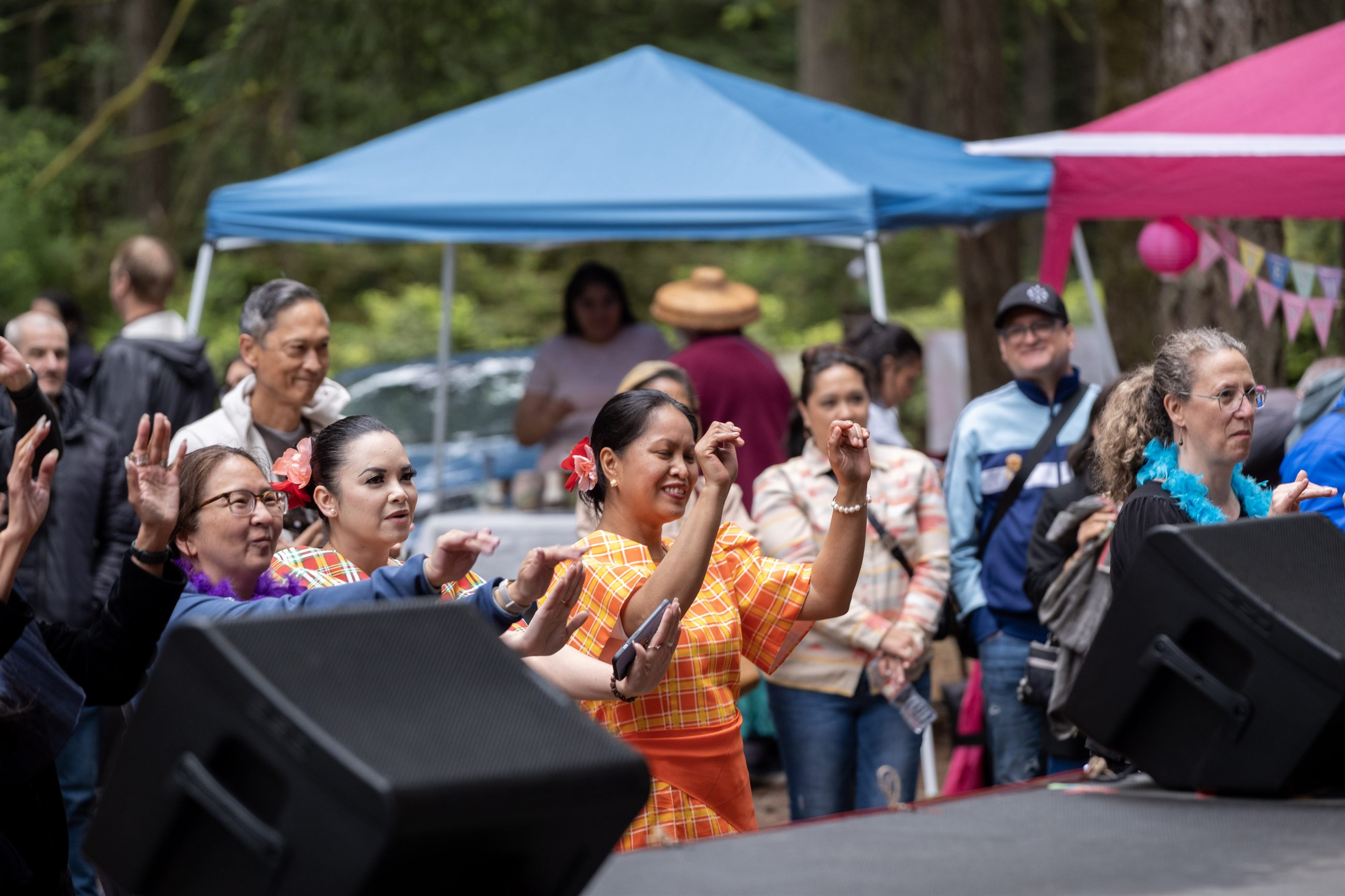 Families, neighbors, and elders participating in a festival community moment.